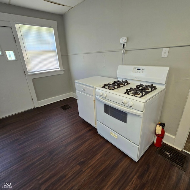 kitchen with white gas range, white cabinetry, and dark hardwood / wood-style floors