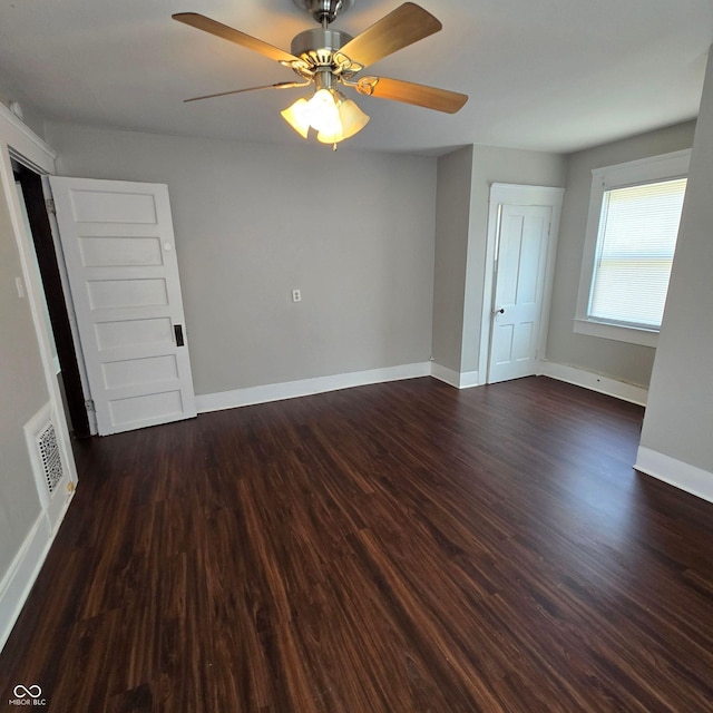 empty room with dark wood-type flooring and ceiling fan