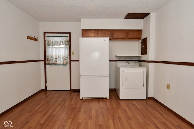 laundry room with washer / dryer, a textured ceiling, and light hardwood / wood-style floors