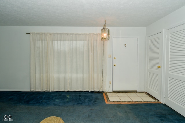 entryway with carpet flooring and a textured ceiling