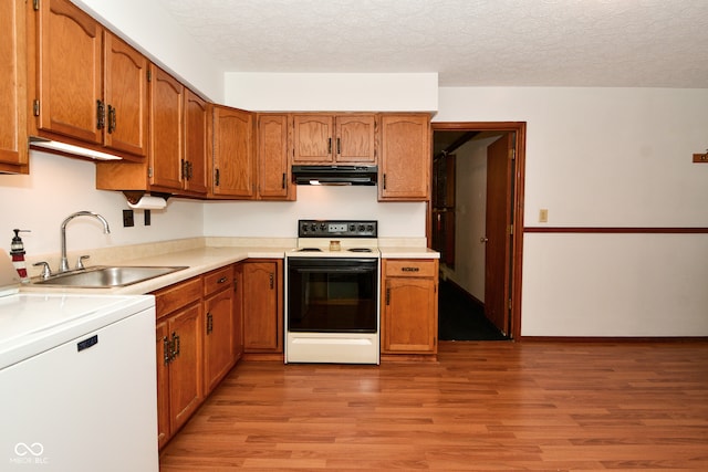 kitchen featuring washer / dryer, sink, white range with electric stovetop, a textured ceiling, and light hardwood / wood-style floors