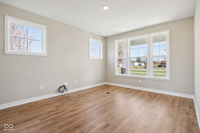 spare room featuring light hardwood / wood-style flooring and a healthy amount of sunlight