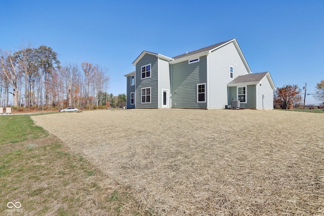 rear view of house with a lawn and central air condition unit