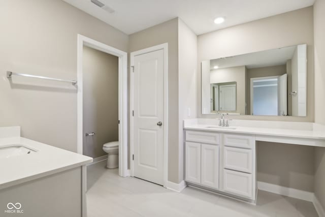 bathroom with tile patterned flooring, vanity, and toilet