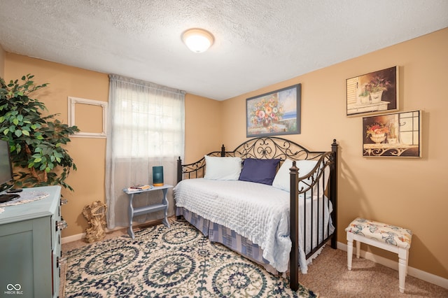 bedroom with a textured ceiling and carpet flooring