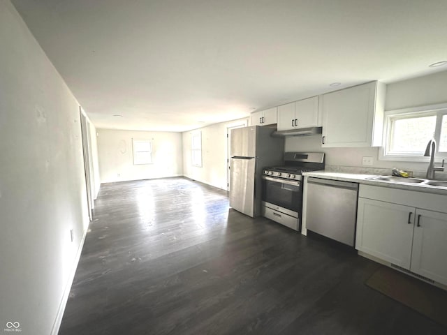 kitchen with sink, white cabinets, dark wood-type flooring, and stainless steel appliances