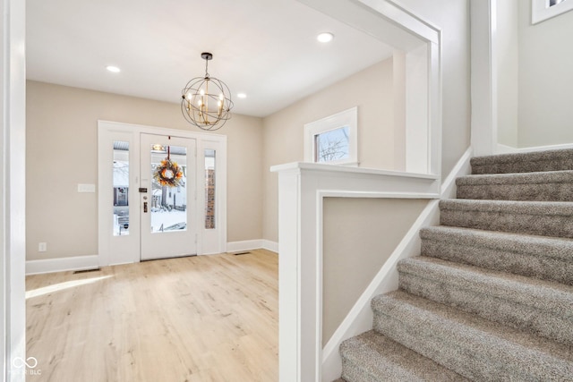 foyer with light hardwood / wood-style flooring and a notable chandelier