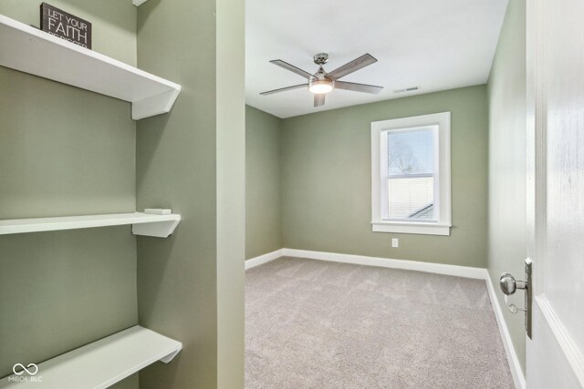 carpeted spare room featuring ceiling fan