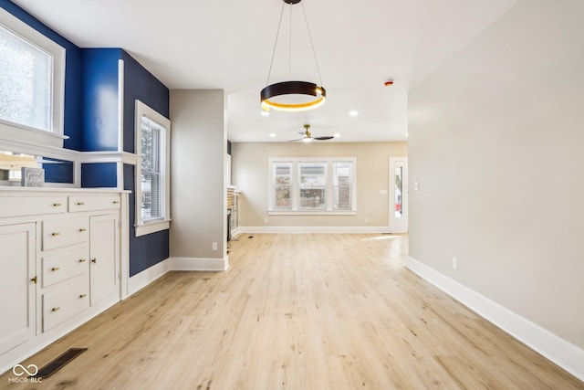 unfurnished living room featuring light hardwood / wood-style flooring and ceiling fan