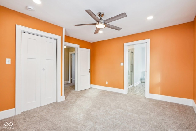 unfurnished bedroom featuring ceiling fan, ensuite bath, light carpet, and a closet