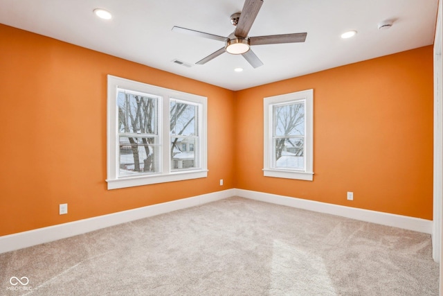 empty room featuring ceiling fan and light carpet