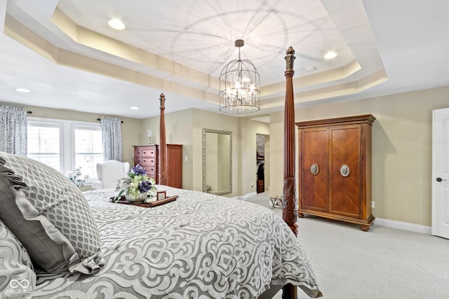 bedroom with a raised ceiling, light carpet, and an inviting chandelier