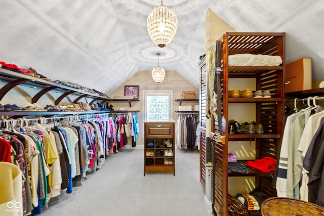 spacious closet featuring light carpet, vaulted ceiling, and an inviting chandelier