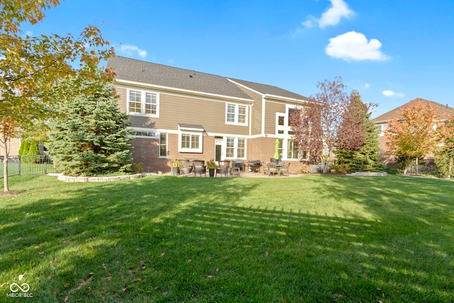 back of property with a lawn and a patio area