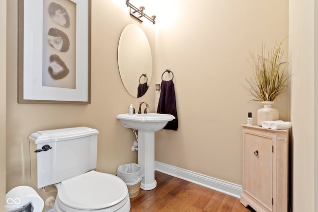 bathroom with hardwood / wood-style floors and toilet