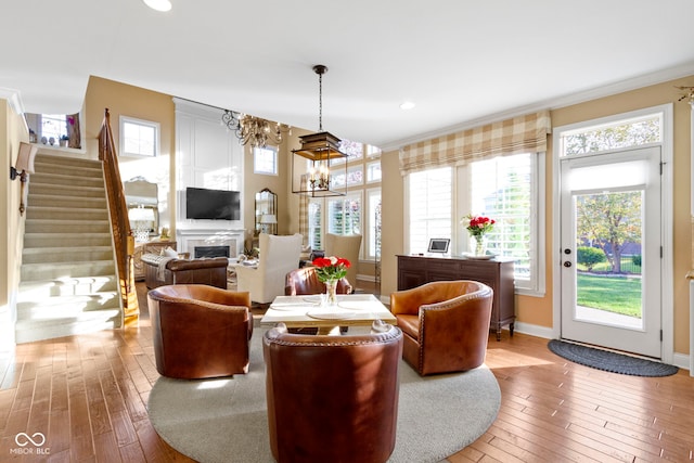 living room with ornamental molding, a chandelier, and hardwood / wood-style flooring