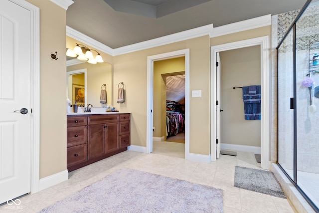 bathroom with tile patterned flooring, vanity, a shower with door, and crown molding