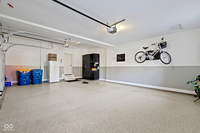 garage with black fridge, a garage door opener, and white refrigerator