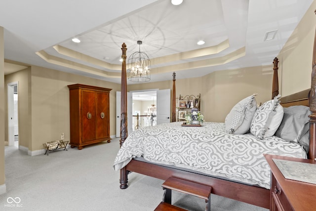 carpeted bedroom featuring a chandelier and a raised ceiling