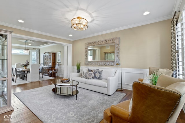 living room with a chandelier, wood-type flooring, and ornamental molding