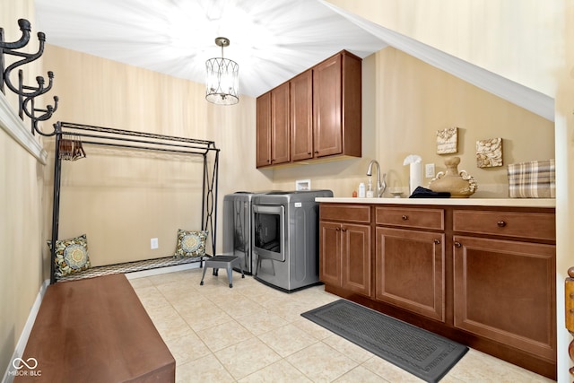 laundry room featuring cabinets, sink, light tile patterned floors, an inviting chandelier, and independent washer and dryer