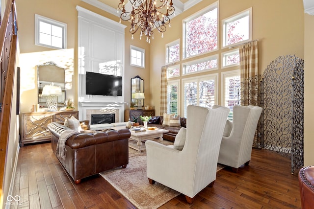 living room with a wealth of natural light, dark hardwood / wood-style flooring, and a high ceiling