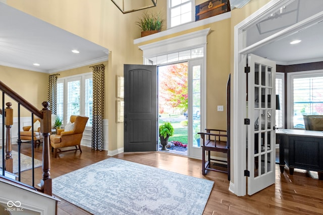 entrance foyer with hardwood / wood-style floors and ornamental molding