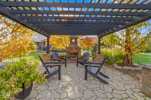 view of patio with a pergola and an outdoor stone fireplace