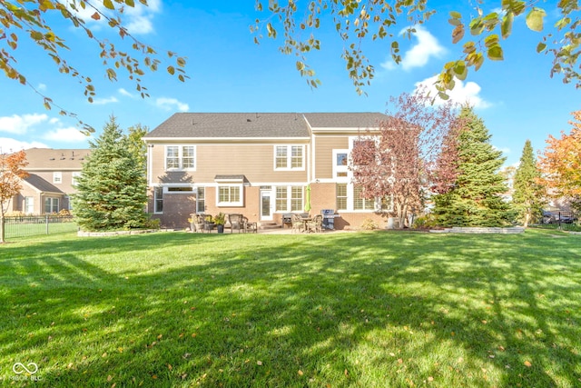 back of house with a yard and a patio