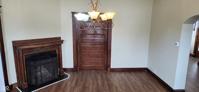 unfurnished dining area featuring an inviting chandelier and dark hardwood / wood-style flooring