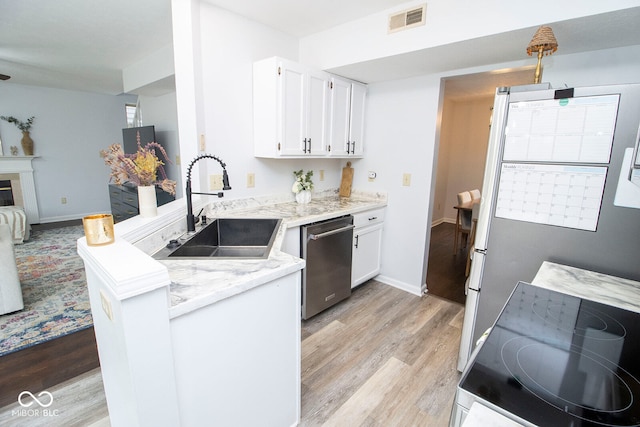 kitchen featuring light wood-type flooring, sink, white cabinets, dishwasher, and kitchen peninsula