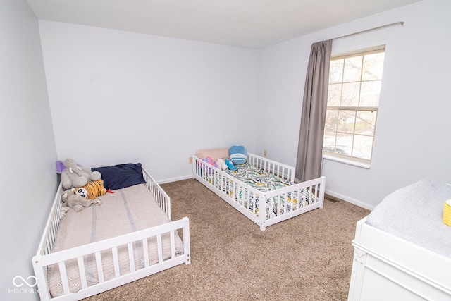 bedroom featuring a nursery area and carpet