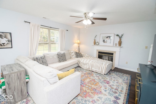 living room with dark hardwood / wood-style flooring and ceiling fan