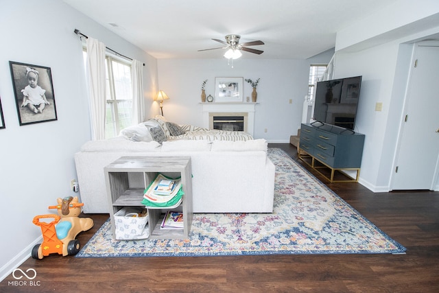 living room featuring dark wood-type flooring and ceiling fan