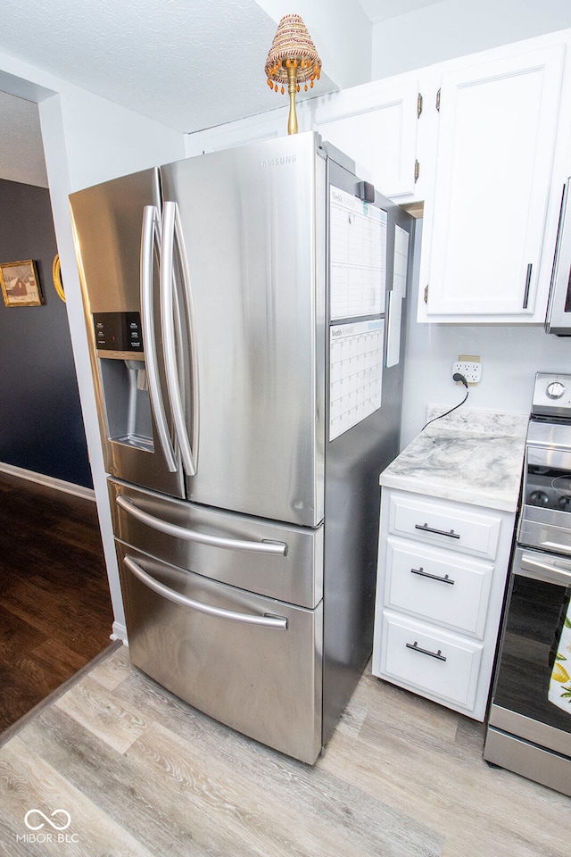 kitchen with white cabinetry, light hardwood / wood-style floors, and stainless steel appliances