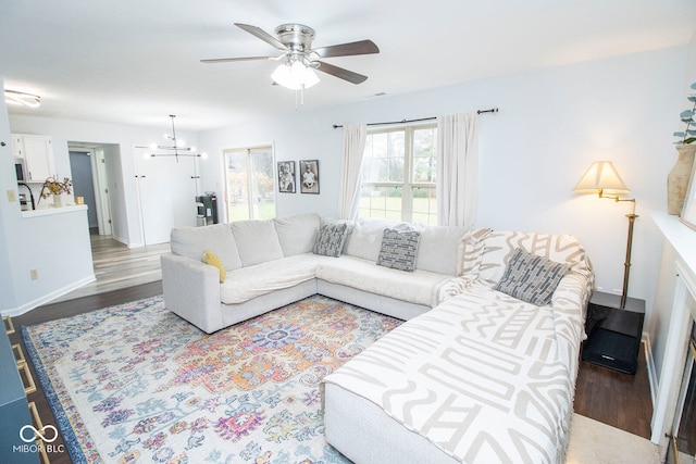 living room featuring hardwood / wood-style floors and ceiling fan with notable chandelier