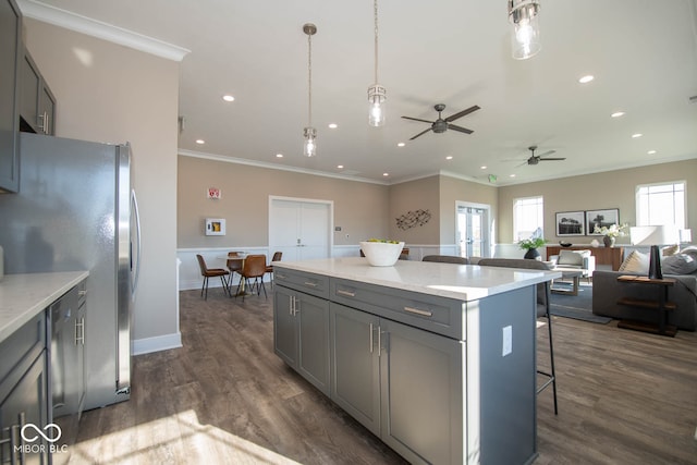 kitchen featuring dark hardwood / wood-style flooring, a kitchen bar, hanging light fixtures, and gray cabinets