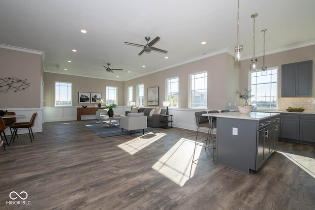 kitchen featuring dark hardwood / wood-style floors, a center island, hanging light fixtures, gray cabinetry, and a breakfast bar area