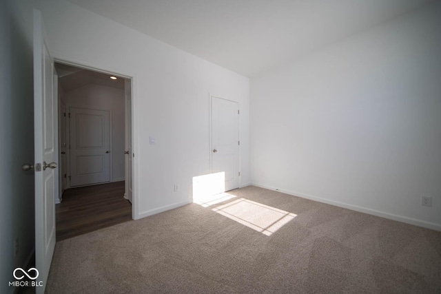 spare room with dark colored carpet