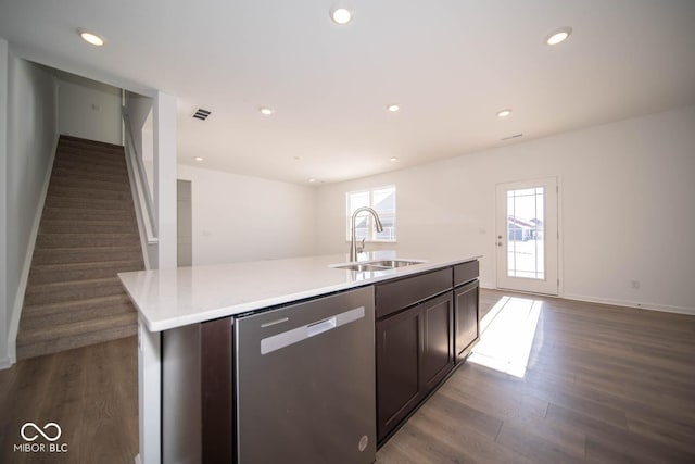 kitchen with a kitchen island with sink, dark hardwood / wood-style flooring, dark brown cabinets, dishwasher, and sink