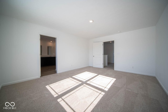 unfurnished bedroom with light carpet and ensuite bath