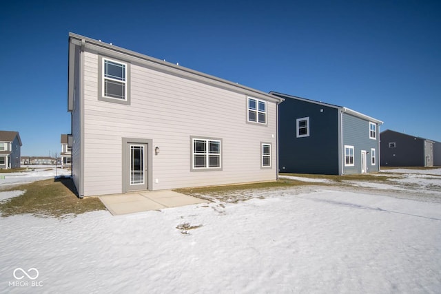 snow covered property featuring a patio