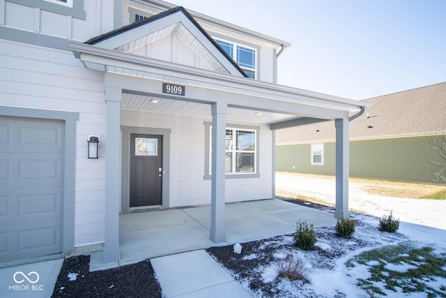 doorway to property featuring covered porch and a garage