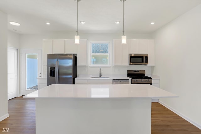 kitchen featuring appliances with stainless steel finishes, white cabinetry, sink, and a kitchen island