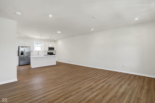 unfurnished living room with sink and dark hardwood / wood-style flooring