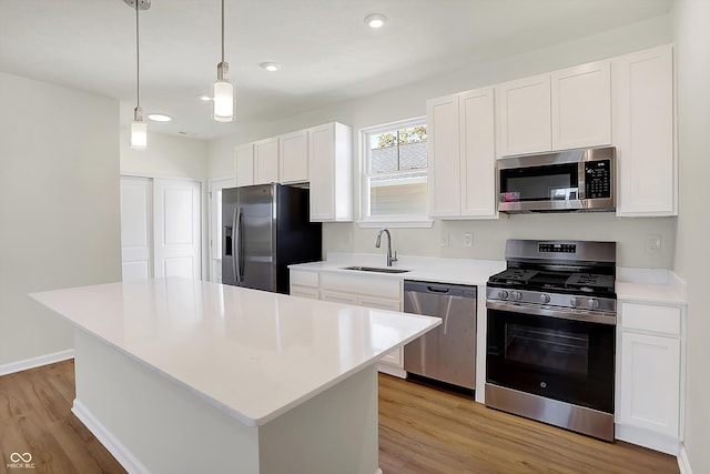 kitchen with a center island, white cabinetry, decorative light fixtures, and stainless steel appliances