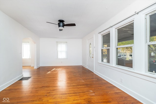 unfurnished room featuring ceiling fan, hardwood / wood-style floors, and plenty of natural light