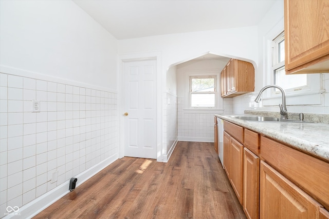 kitchen featuring light stone countertops, tile walls, dark hardwood / wood-style flooring, and sink