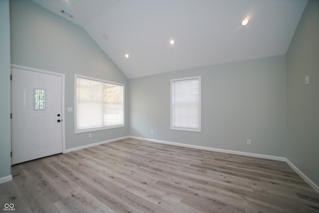 foyer entrance featuring high vaulted ceiling and light hardwood / wood-style flooring