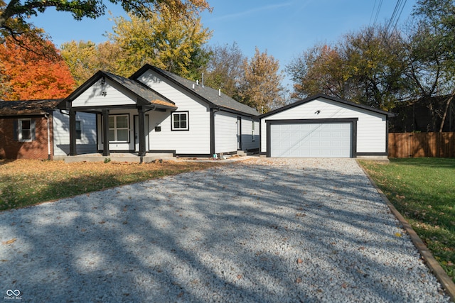 view of front of home with a front yard, an outdoor structure, and a garage